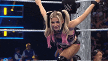 a woman in a wrestling ring with the letter w on the back of her shirt