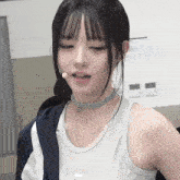 a girl wearing a choker and a white tank top with the word puma on the front