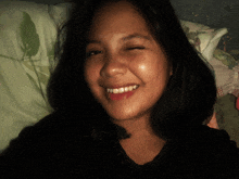 a woman is smiling with her eyes closed and her teeth visible