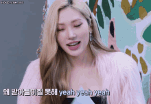 a woman with blonde hair is wearing a pink fur coat and says yeah yeah yeah .