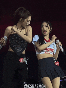 two women singing on a stage with the words @ksbaemon written on the bottom