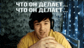 a man wearing headphones and a yellow shirt with the words " что он делает " on the bottom