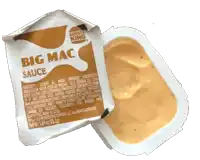 a packet of burger king big mac sauce sits next to a container of sauce