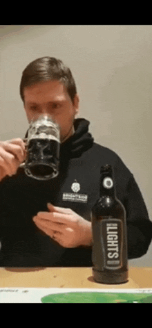 a man is drinking from a mug next to a bottle that says heights