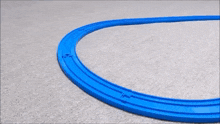 a toy train is going around a blue curve