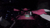 a red robot with a green light coming out of it 's mouth