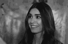 a black and white photo of a woman smiling in a black and white photo .