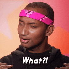 a man wearing a pink headband has the word what written on his shirt