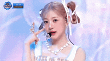 a girl is singing into a microphone while wearing a necklace of stars .