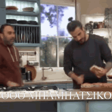 two men in a kitchen with a sign that says ooo miamatsiko