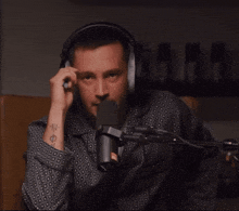 a man with a tattoo on his wrist is wearing headphones and covering his face