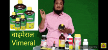 a man in a pink shirt is standing in front of a table full of vimeral bottles