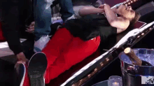 a man in red pants is laying on a bed next to a bottle of champagne and a mtv logo