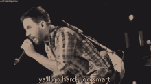 a man singing into a microphone with the words ya 'll go hard i go smart in the corner