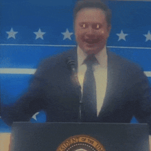 a man in a suit and tie stands behind a podium that says president of the united states on it
