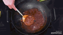 a sauce is being poured into a pan with a wooden spoon and the words made in animatica visible in the corner