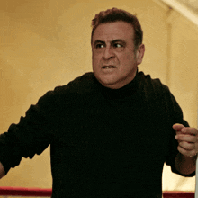 a man in a black sweater is making a face