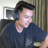 a man wearing headphones and a black shirt that says nvento madrid