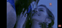 a man and a woman are kissing in the water in a dark room .
