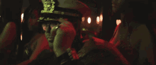 a man in a military hat and glasses is dancing in a club