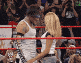 a man and a woman are standing in a wrestling ring with a sign that says ance