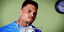 chris brown is wearing a surgical gown and holding a pair of scissors in his mouth .