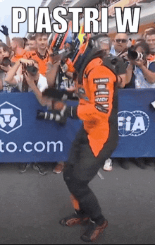 a man is dancing in front of a sign that says piastri w