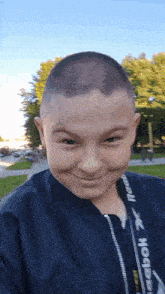 a young boy wearing a reebok jacket looks at the camera