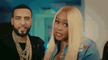 a man and a woman are standing next to each other . the woman is wearing a denim jacket .