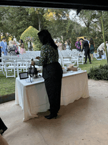 a woman stands at a table with a tablet on it