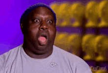a man wearing a hat and a t-shirt is making a surprised face and saying oh .