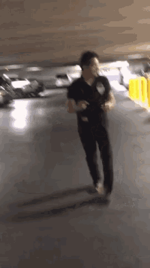 a man in a black shirt is running on a parking lot