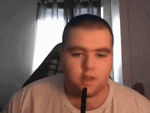 a man in a white t-shirt is smoking a hookah .