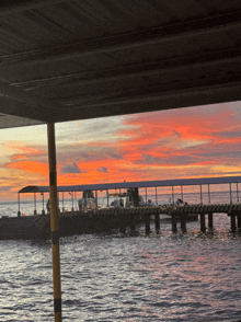 a sunset over a dock with boats docked at it