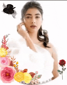 a woman in a white dress is surrounded by flowers and a black hat