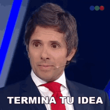 a man in a suit and tie with the words termina tu idea below him
