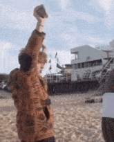 a person is standing on a beach holding a rock in their hand .
