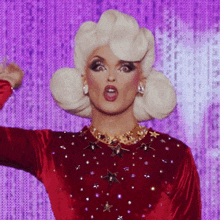 a drag queen with white hair and a red top