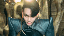 a close up of a man wearing a black costume and a necklace with spikes on it .