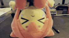 a stuffed animal with a sad face is sitting on a table