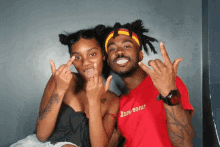 a man and a woman are posing for a picture and the man is wearing a red shirt that says entrepreneur