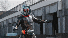 a man in a masked superhero costume stands in front of a building with his arms outstretched