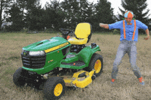 a man is dancing in front of a john deere tractor