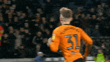 a soccer player wearing an orange jersey with the number 31 on the back