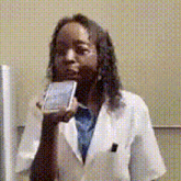 a woman in a white lab coat is holding a cell phone