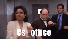a man and a woman are clapping in front of a sign that says cs_office .