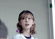 a girl holding a purple bottle of water