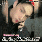 a blurred image of a man talking on a cell phone with the words jin lor mak mak written below him
