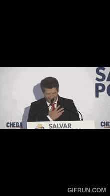 a man stands in front of a podium that says salvar