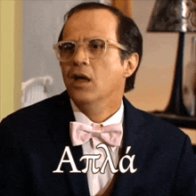 a man wearing glasses and a pink bow tie has the word atlas written in white letters